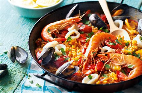  Paella Valenciana: A Symphony of Savory Seafood and Rustic Rice Delights!